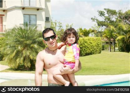 Father and daughter beside the swimming pool