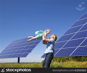 Father and daughter by solar panels