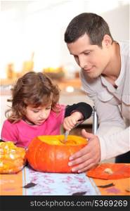 Father and daughter carving pumpkins