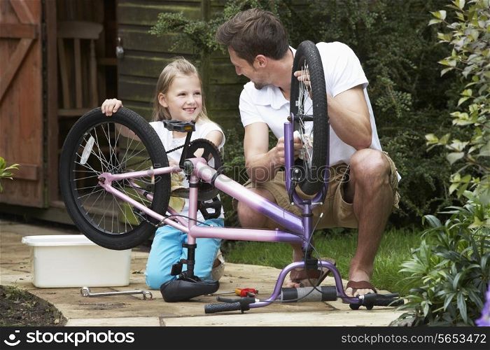 Father And Daughter Cleaning Bike Together