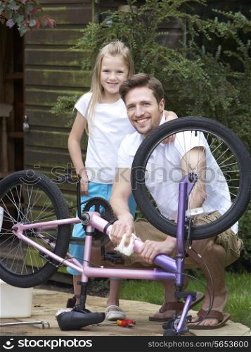 Father And Daughter Cleaning Bike Together