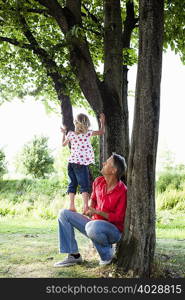 Father and Daughter Climbing on Tree