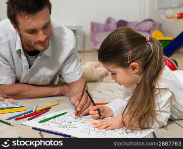 Father and Daughter Coloring Together on Floor