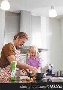 Father and Daughter Cooking in Kitchen