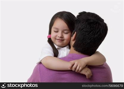 Father and daughter embracing over white background