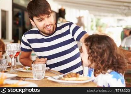Father And Daughter Enjoying Meal In Restaurant