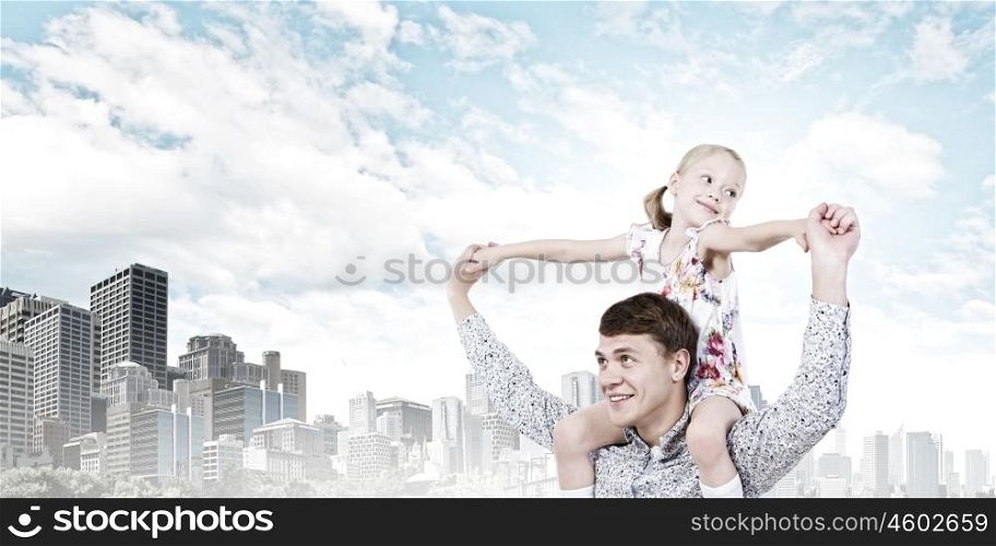 Father and daughter. Happy daughter sitting on shoulders of her father