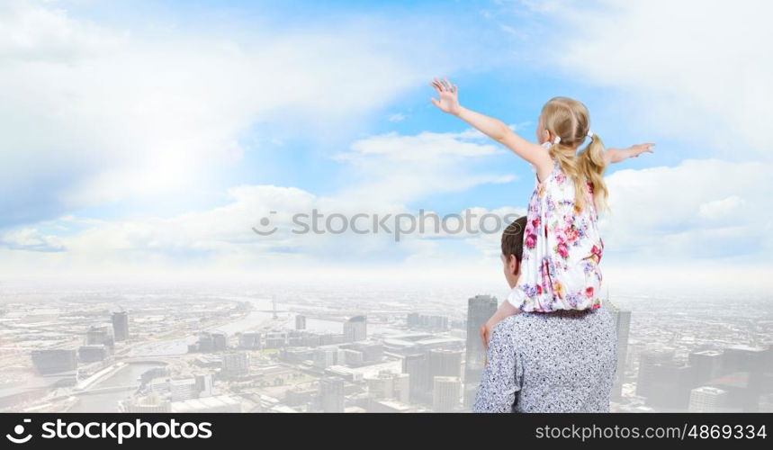 Father and daughter. Happy daughter sitting on shoulders of her father