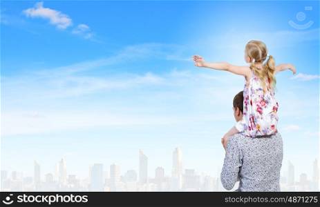 Father and daughter. Happy daughter sitting on shoulders of her father