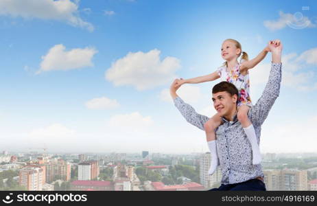 Father and daughter. Happy daughter sitting on shoulders of her father