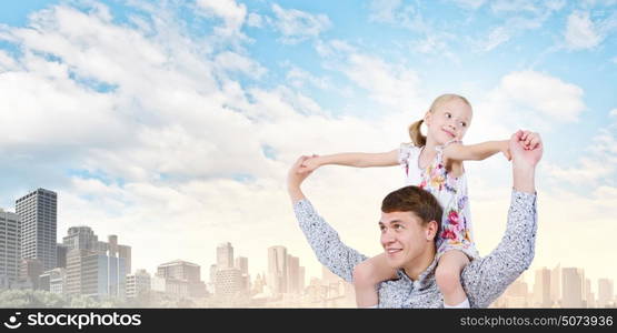 Father and daughter. Happy daughter sitting on shoulders of her father