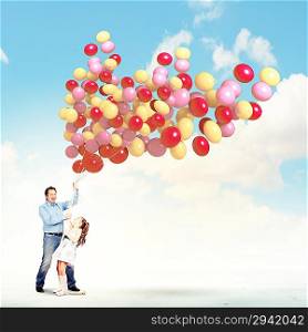 Father and daughter holding balloons