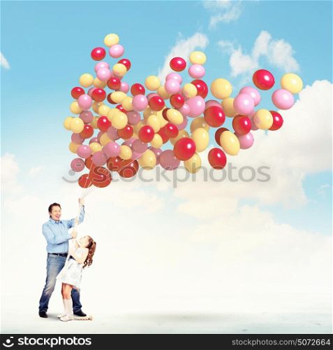 Father and daughter holding balloons. Image of father and daughter holding bunch of colorful balloons