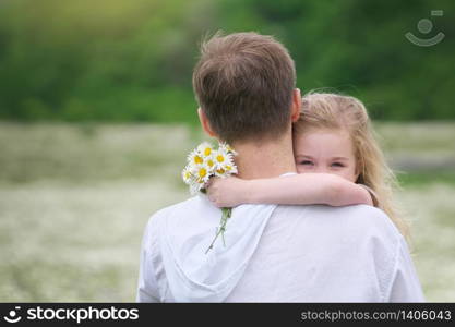 Father and daughter in big camomile mountain meadow. Emotional, love and care scene.