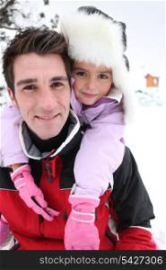 Father and daughter in the snow