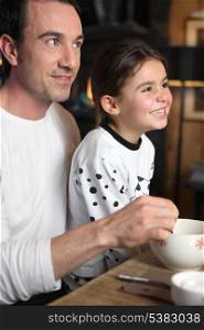 Father and daughter laughing at breakfast