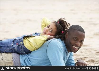 Father and daughter laying on beach