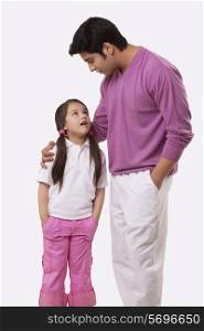 Father and daughter looking at each other over white background