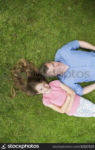 Father and daughter lying on grass