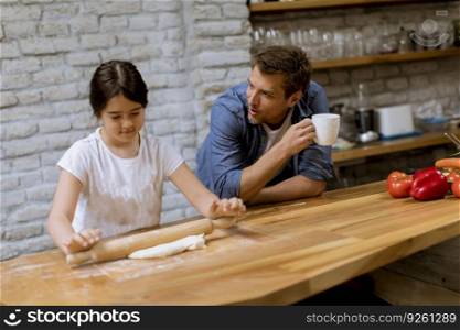 Father and daughter making bread in the rustic kitchen
