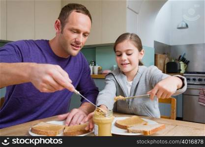 Father and daughter making sandwiches