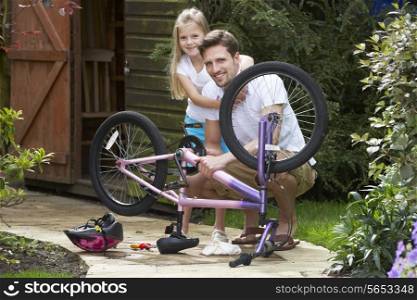 Father And Daughter Mending Bike Together