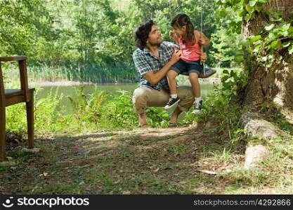 Father and daughter on swing