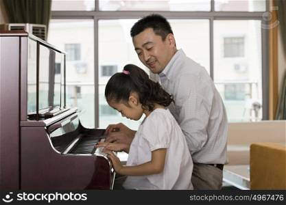 Father and daughter playing the piano
