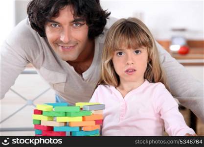 Father and daughter playing with bricks