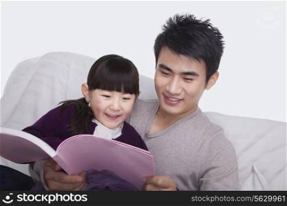 Father and daughter reading on the sofa