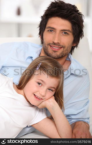 Father and daughter relaxing on a sofa