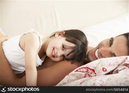 Father And Daughter Relaxing Together In Bed