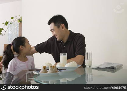 Father and daughter sat at a table