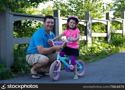 Father and daughter sharing a happy moment while learning to ride a bicycle