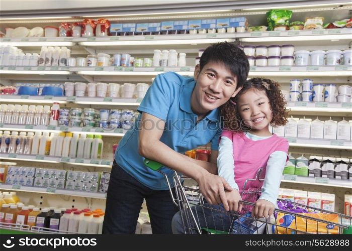 Father and Daughter Shopping in Supermarket, Looking at camera
