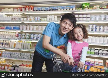 Father and Daughter Shopping in Supermarket, Looking at camera