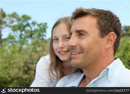 Father and daughter sitting in park