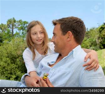 Father and daughter sitting in park