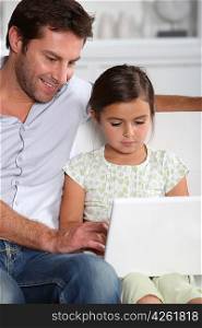 Father and daughter using computer together