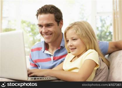 Father And Daughter Using Laptop At Home