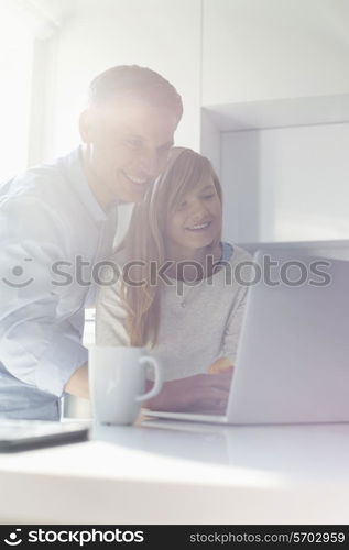 Father and daughter using laptop at home