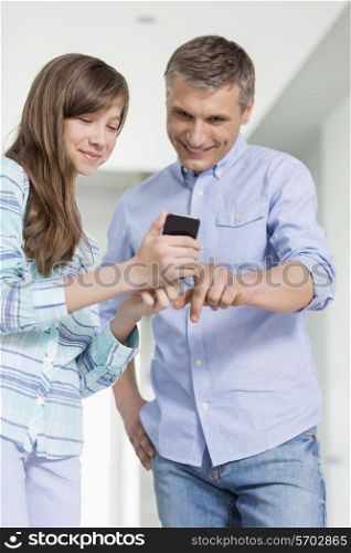 Father and daughter using smart phone at home