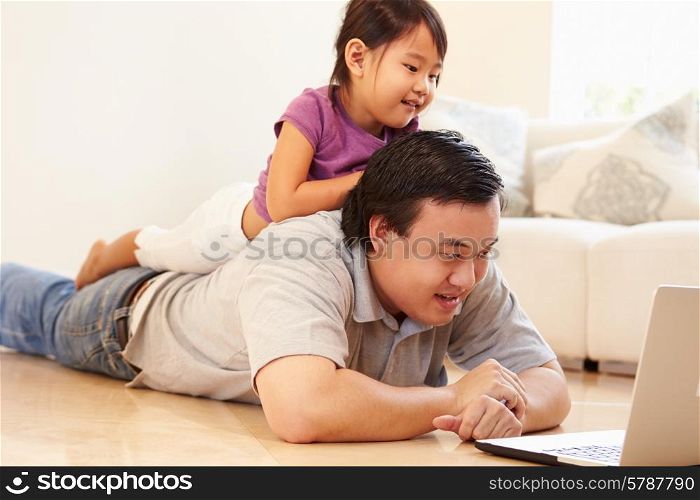 Father And Daughter Watching Movie On Laptop At Home