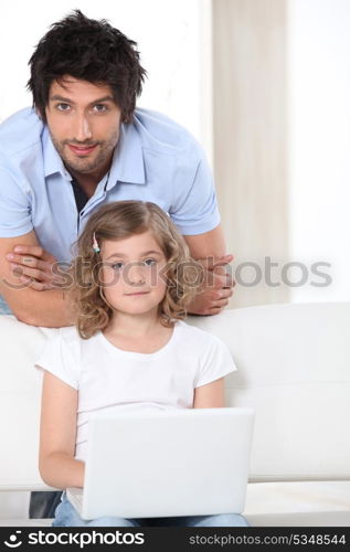 Father and daughter with white laptop