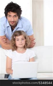Father and daughter with white laptop