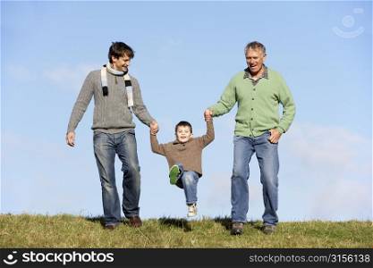 Father And Grandfather Swinging Young Boy