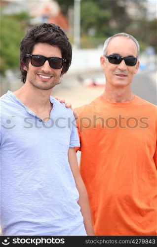 Father and grownup son wearing shades