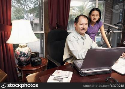 Father and his daughter looking at a laptop