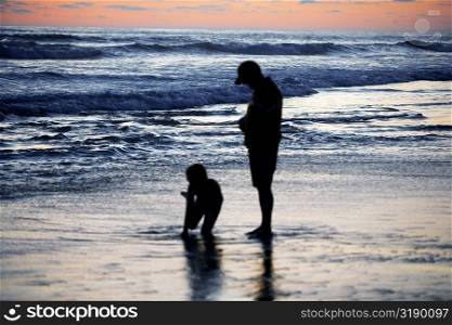 Father and his daughter playing in the water at the beach