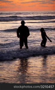 Father and his daughter playing in the water at the beach
